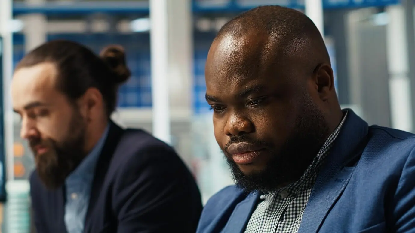 Ingenieure im Fabrikbüro verwenden einen Laptop, um Leistungsdaten zu erfassen und die Entwürfe zur Steigerung zu verfeinern.